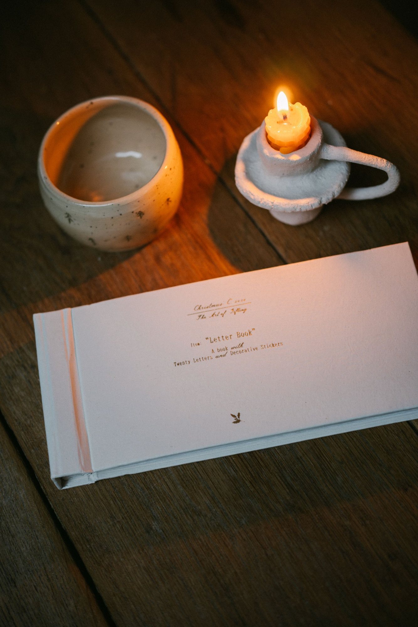 A candle and a letter on a wooden table